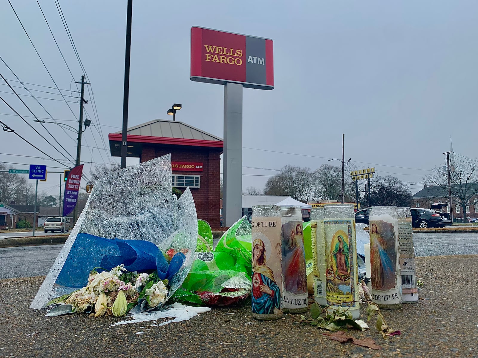 A memorial of flowers and candles sit on a sidewalk at the Wells Fargo ATM where Juan Lopez was gunned down Nov. 26.