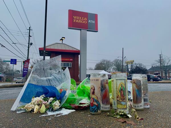 A memorial of flowers and candles sits on a sidewalk at the Wells Fargo ATM where Juan Lopez was gunned down Nov. 26.