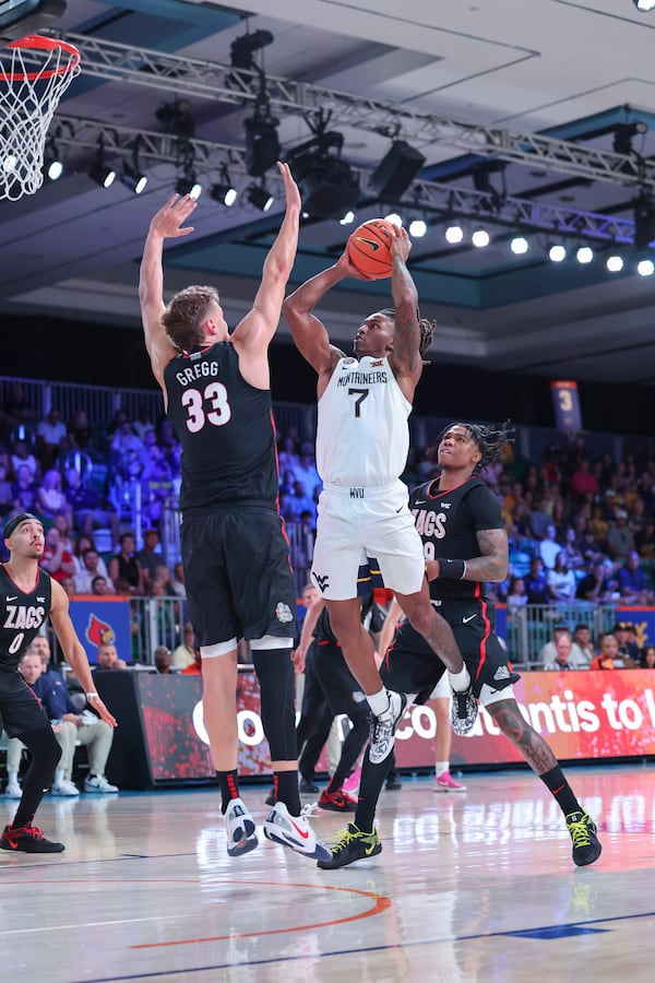 In this handout provided by Bahamas Visual Services, West Virginia guard Javon Small (7) takes a shot as Gonzaga forward Ben Gregg (33) defends during an NCAA college basketball game at the Battle 4 Atlantis tournament in Paradise Island, Bahamas Wednesday, Nov. 27, 2024. (Tim Aylen/Bahamas Visual Services via AP)