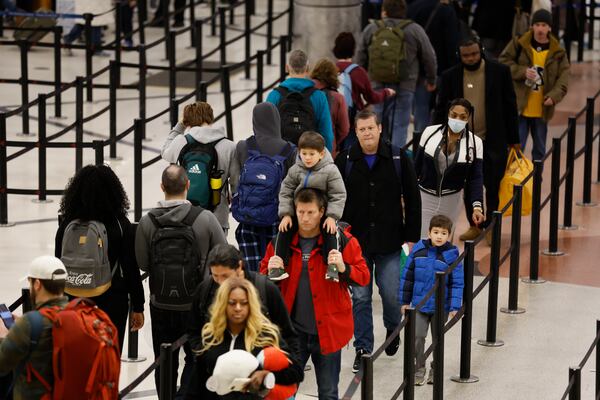 Travelers stand in line going through a security checkpoint at Hartsfield-Jackson Atlanta International Airport ahead of Christmas weekend. Hartsfield-Jackson advises travelers to get to the airport 2.5-3 hours before their flights. Miguel Martinez / miguel.martinezjimenez@ajc.com