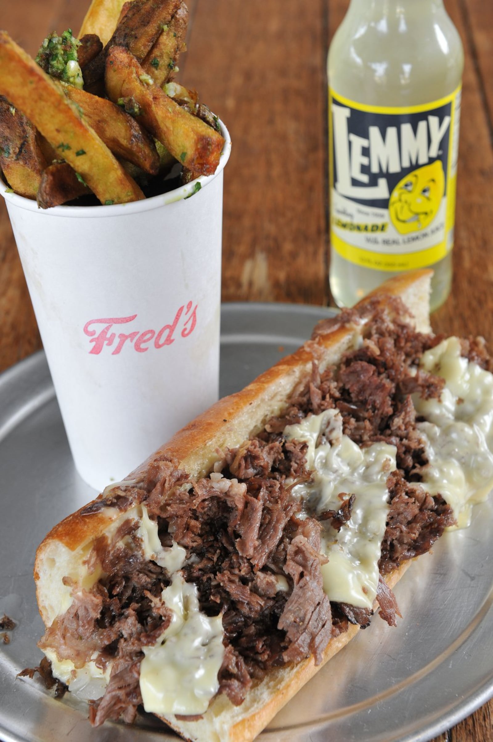 The cheesesteak at Fred’s Meat & Bread, inside the Krog Street Market, comes with onions and American cheese. You might want to add garlic fries and a Lemmy lemonade to that. (Becky Stein / beckysteinphotography.com)