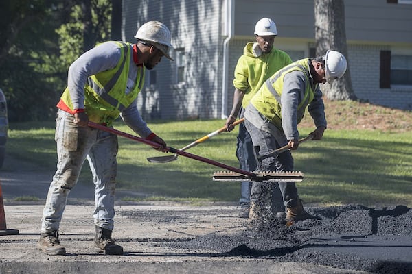 An H.E.H. Paving crew works to lay asphalt on Gwendon Terrace in Decatur, Thursday, April 16, 2020. The paving project is part of the DeKalb County Special Purpose Local Option Sales Tax. (ALYSSA POINTER / ALYSSA.POINTER@AJC.COM)