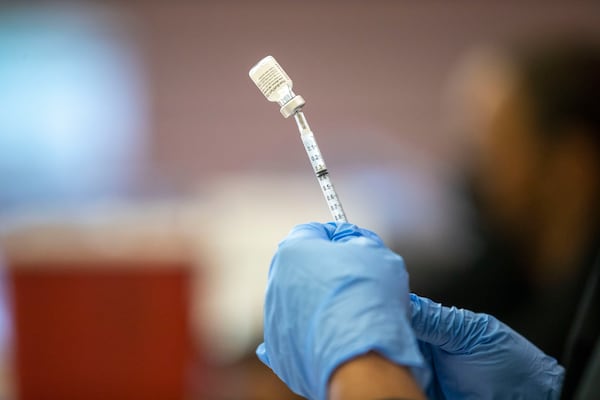 A registered nurse prepares a dose of the Pfizer COVID-19 vaccine during a free vaccination event held at Discovery High School in Lawrenceville on Aug. 18. (Alyssa Pointer / Alyssa.Pointer@ajc.com)