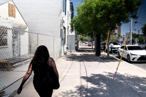 Buttons walks down a Las Vegas street Wednesday, June 26, 2024. "Adoption tells you: you're an American, this is your home. But the United States doesn't see me as an American," said Buttons who feels she lives in the shadows because of her immigration status. (AP Photo/David Goldman)