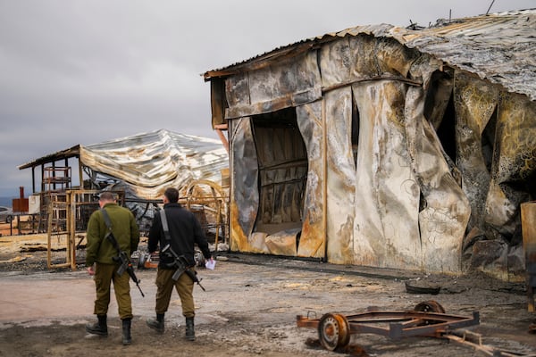 Israel soldiers walk next to a damaged animal farm hit by a rocket fired from Lebanon in Avivim, northern Israel, near the border with Lebanon, Wednesday, Nov. 27, 2024. (AP Photo/Francisco Seco)