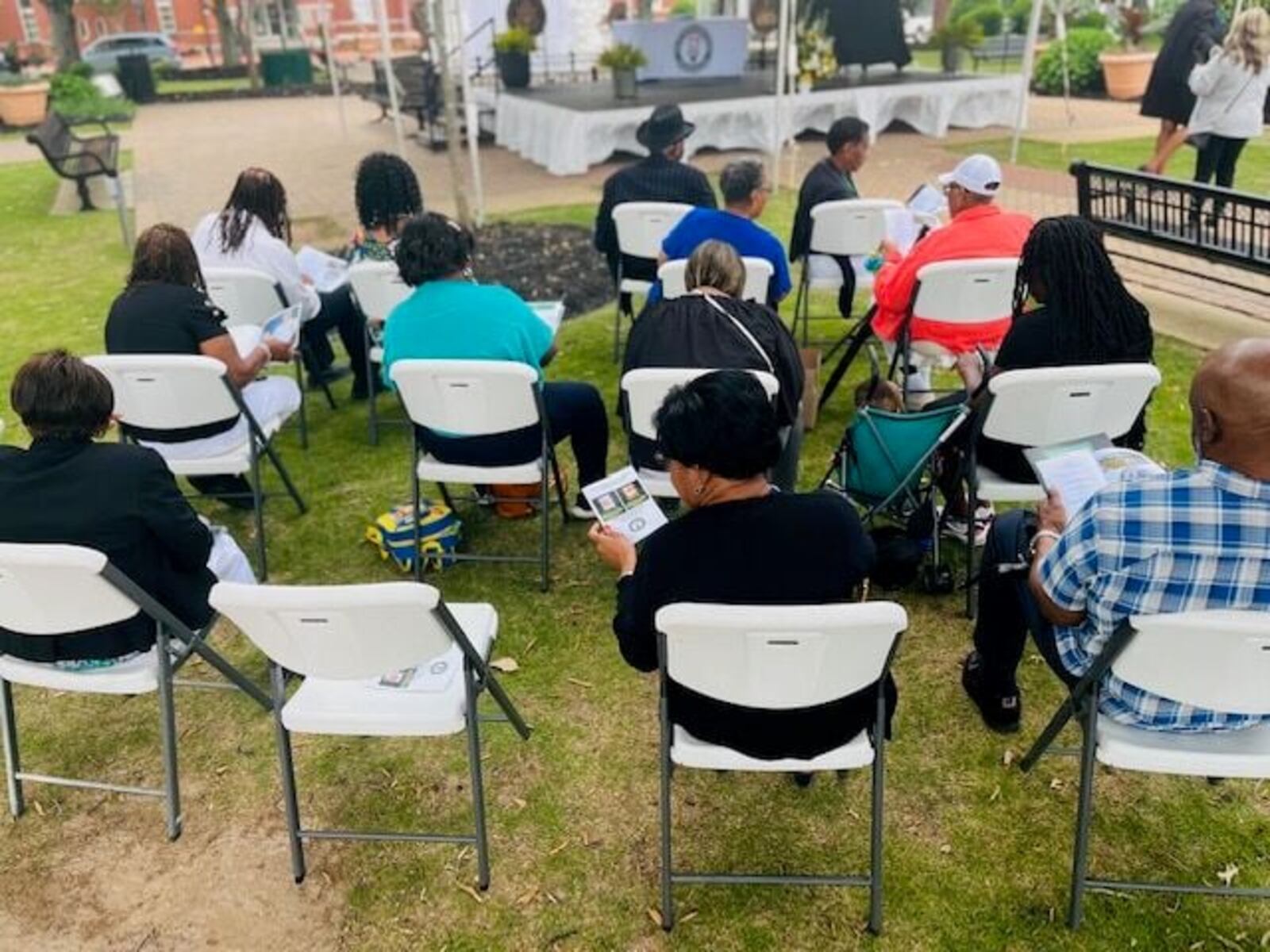 Attendees read through programs for Hattie Miranda Stewart Barnes and Mary Alberta Childs during a Street Dedication Ceremony held in commemoration of the mother-daughter midwives at the McDonough Square on Friday, May 12. (Photo Courtesy of Henry Herald)