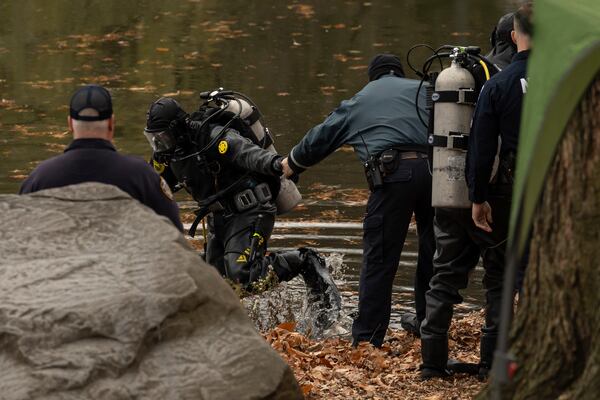 NYPD officers in diving suits search a lake in Central Park, Monday, Dec. 9, 2024, in New York. (AP Photo/Yuki Iwamura)