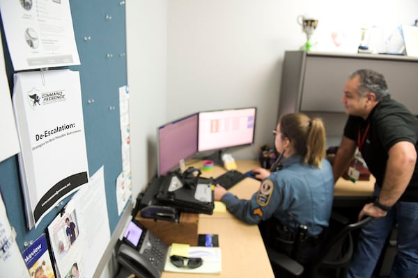 Gwinnett County Police officer Cpl. Tracy Reed (left) is seen with Pej Mahdavi, director of intensive outpatient services at Viewpoint Health, in their office Thursday, Dec. 16, 2021 at the Gwinnett County Police Department . The duo is Gwinnett County’s only behavioral health unit and provides resources for people who interact with the police. (Daniel Varnado/ For the Atlanta Journal-Constitution)