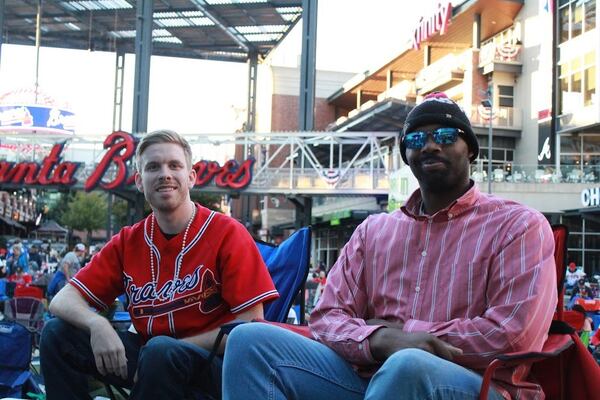 Kevin Dae of Powder Springs (left) and his friend Marcus Bass of Acworth joined other Atlanta Braves fans Tuesday night, October 26, 2021, to watch Game 1 of the World Series on giant screens at The Battery, adjacent to Truist Park, home of the Atlanta Braves. Game 1 was played at Minute Maid Park in Houston, Texas. (Credit: Sarah Swetlik for The Atlanta Journal-Constitution)