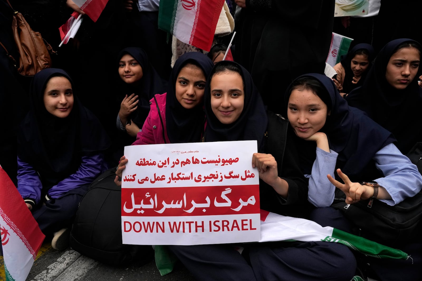 An Iranian schoolgirl holds an anti-Israeli placard during an annual rally in front of the former U.S. Embassy in Tehran, Iran, Sunday, Nov. 3, 2024, marking the 45th anniversary of Iranian students' takeover of the embassy, starting a hostage crisis. (AP Photo/Vahid Salemi)