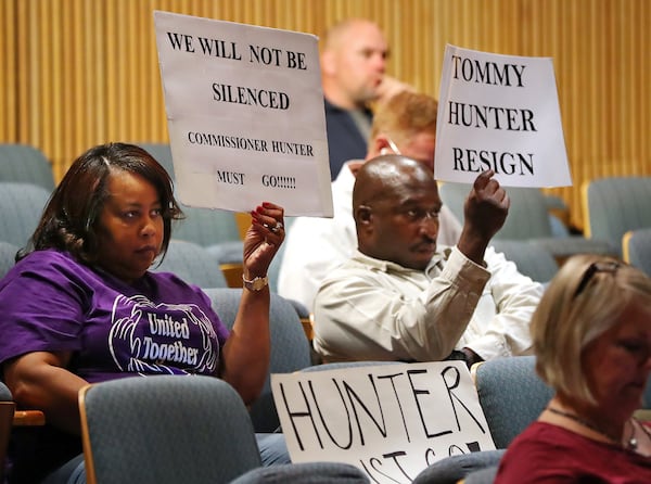 February 28, 2017, Lawrenceville: Phyllis Richardson and Michael Richardson (not related) hold signs during a Gwinnett County Board of Commissioners public hearing while more protesters demand the resignation of Tommy Hunter, the District 3 leader who recently called U.S. Rep. John Lewis a “racist pig” on Facebook. Curtis Compton/ccompton@ajc.com AJC FILE PHOTO