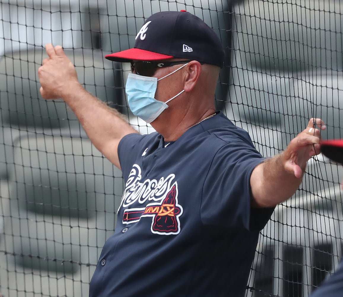 Braves manager Brian Snitker watches from behind a net.  Curtis Compton ccompton@ajc.com