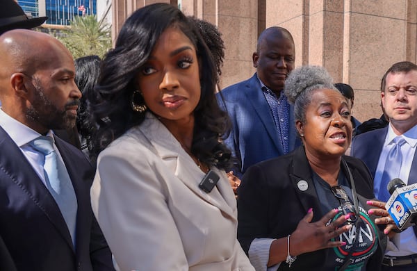 Alphonso David, left, Arian Simone, Fearless Fund co-founder and CEO, and others listen as Serena Paramore, of the National Action Network, gives her remarks after appearing in federal court at the James Lawrence King Federal Justice Building in Miami on Jan. 31 (Carl Juste/The Miami Herald)