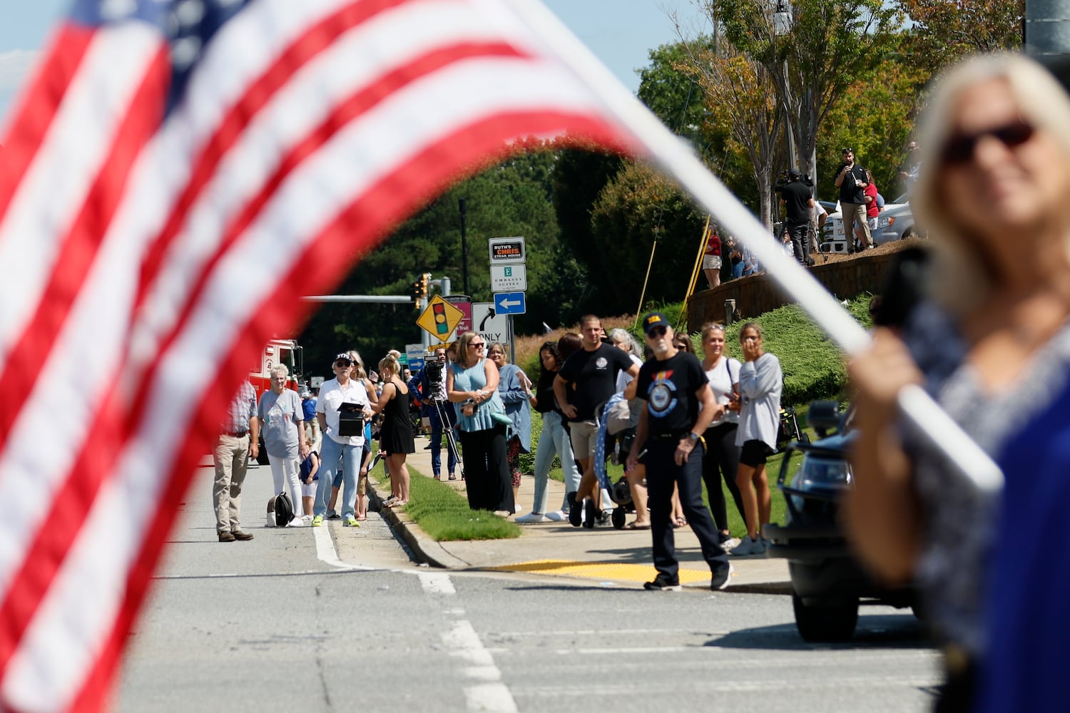 People stand by Chastain Rd to pay respect to fallen Deputy Jonathan Koleski during the procession on Wednesday, September 14, 2022. Miguel Martinez / miguel.martinezjimenez@ajc.com