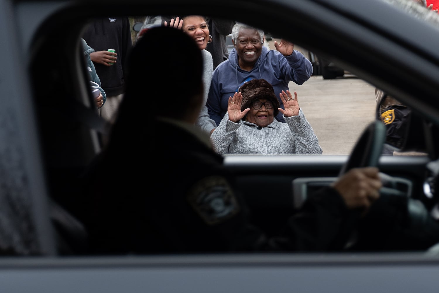 Lillie Mae Hightower waves at a member of the Henry County Sheriff’s Office as a parade pass by in honor of her 102nd birthday in Stockbridge on Friday, Dec. 27, 2024.   Ben Gray for the Atlanta Journal-Constitution