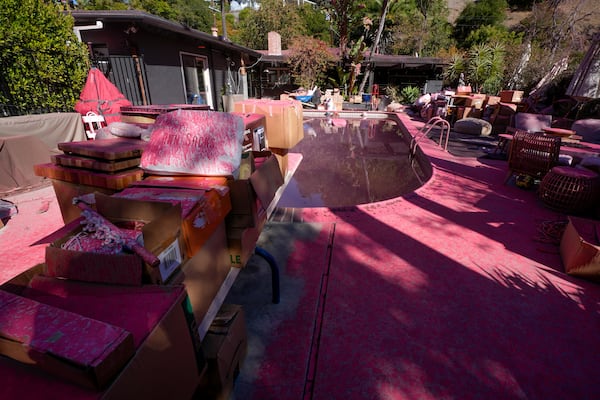 Retardant covers a backyard and pool after crews battled the Palisades Fire in Mandeville Canyon Monday, Jan. 13, 2025 in Los Angeles. (AP Photo/Richard Vogel)