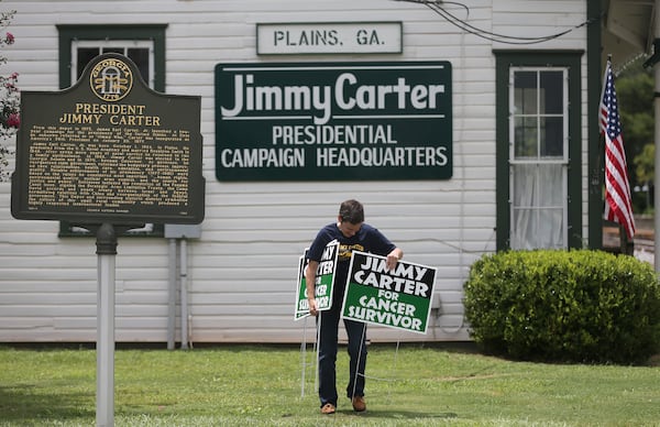 Jill Stuckey places "Jimmy Carter for Cancer Survivor" signs in downtown Plains on Thursday afternoon August 20, 2015 in advance of the President's return to his hometown. Stuckey printed 500 of the signs after seeing one in a Mike Luckovich cartoon drawn just after Carter announced that he had cancer. Ben Gray / bgray@ajc.com