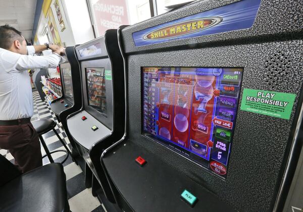 A technician opens a coin-operated amusement machine at a Duluth gas station. Revenue resulting from seized video gaming and poker machines can go to law enforcement agencies. Georgia’s Inspector General is investigating how the Georgia Department of Revenue spent money seized from investigations. BOB ANDRES / BANDRES@AJC.COM