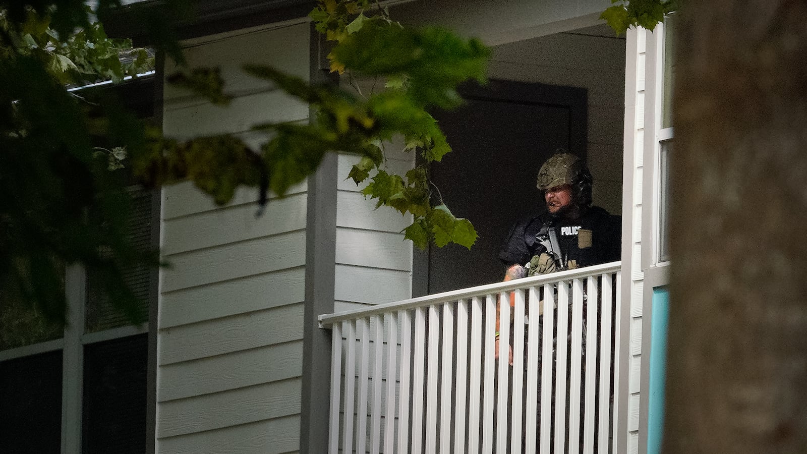 A SWAT team member stands on the balcony where the suspect and hostage were first spotted. 