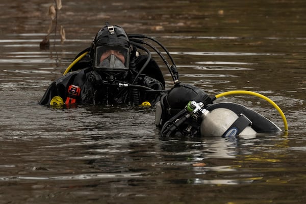 NYPD officers in diving suits search a lake in Central Park, Monday, Dec. 9, 2024, in New York. (AP Photo/Yuki Iwamura)