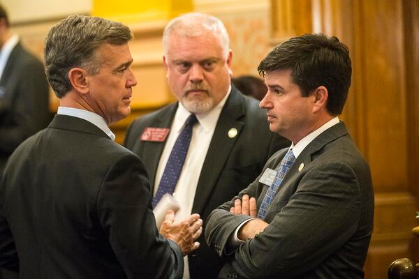 ATLANTA — Georgia Rep. Micah Gravley (center), sponsor of HB 324, looks on as state Rep. Mark Newton (left) speaks with state Sen. Matt Brass (right) in the Senate Chambers on April 2, 2019, the last day of the 2019 legislative session. Sen. Brass carried HB 324, the medical marijuana bill, in the Senate for Gravley. (ALYSSA POINTER/Alyssa.Pointer@AJC.com)