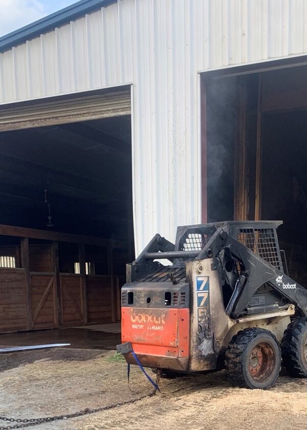 A Bobcat skid-steer loader was engulfed in flames when firefighters arrived at the horse barn.