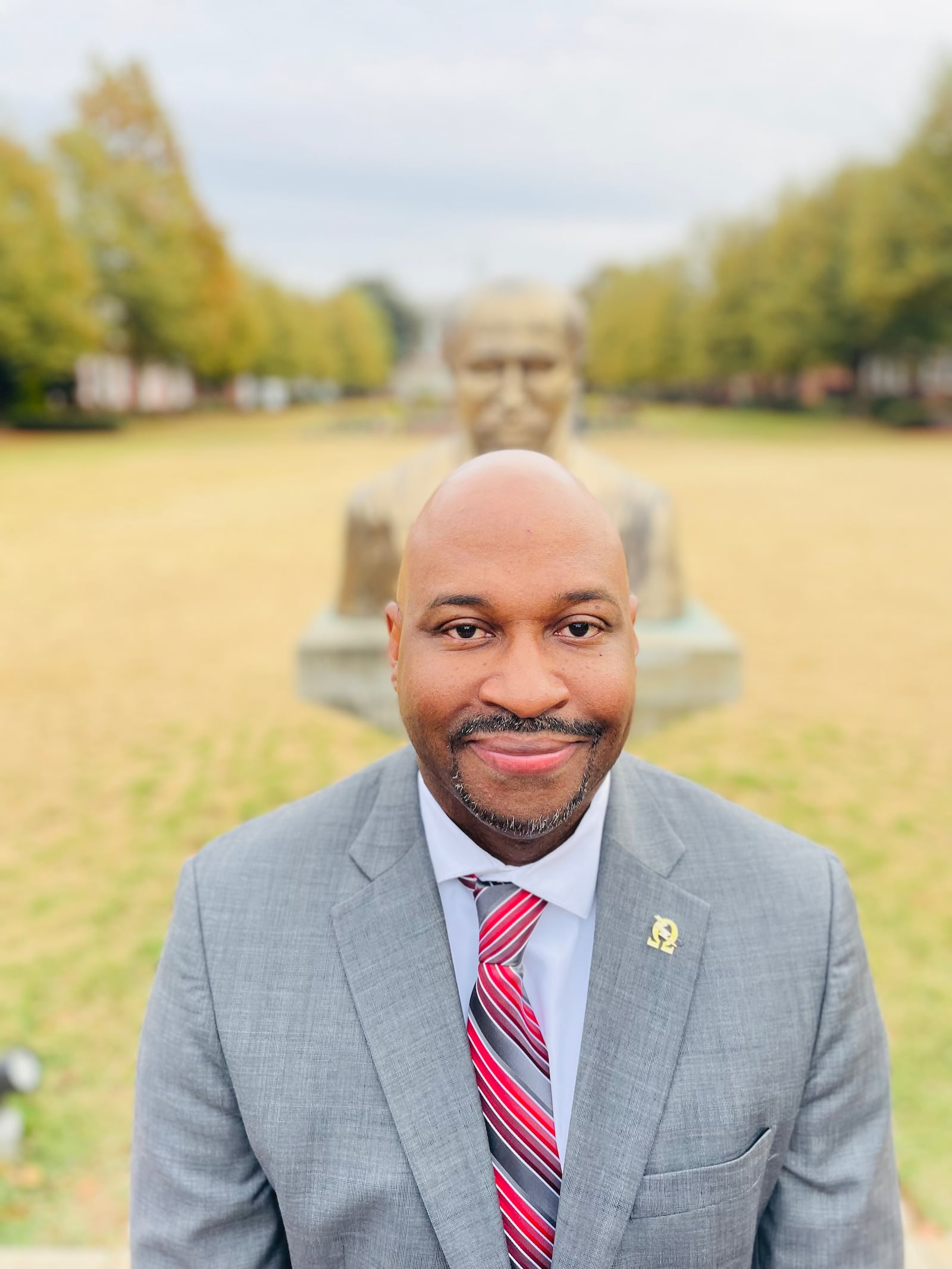 Joseph L. Jones, the director of the W.E.B. Du Bois Southern Center for Studies in Public Policy at Clark Atlanta University, stands in front of a statue of the center's namesake. 