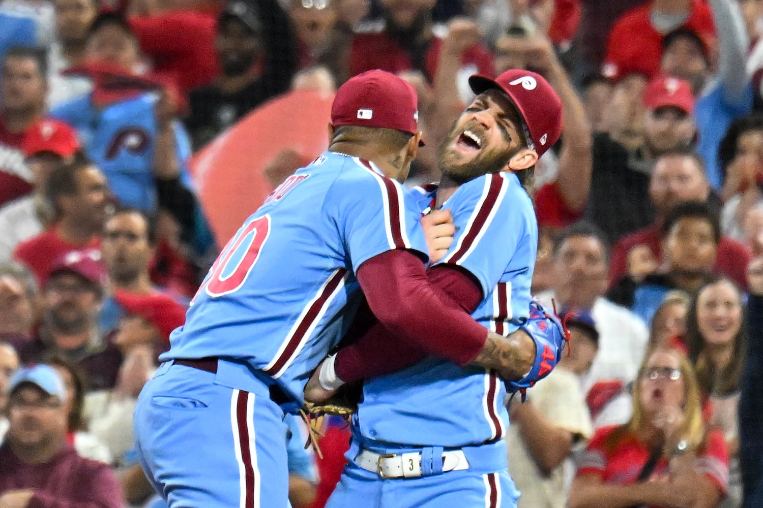 Philadelphia Phillies first baseman Bryce Harper, right, grimaces in the arms relief pitcher Gregory Soto (30) after colliding with Atlanta Braves’ baserunner Matt Olson during the eighth inning of NLDS Game 4 at Citizens Bank Park in Philadelphia on Thursday, Oct. 12, 2023.   (Hyosub Shin / Hyosub.Shin@ajc.com)