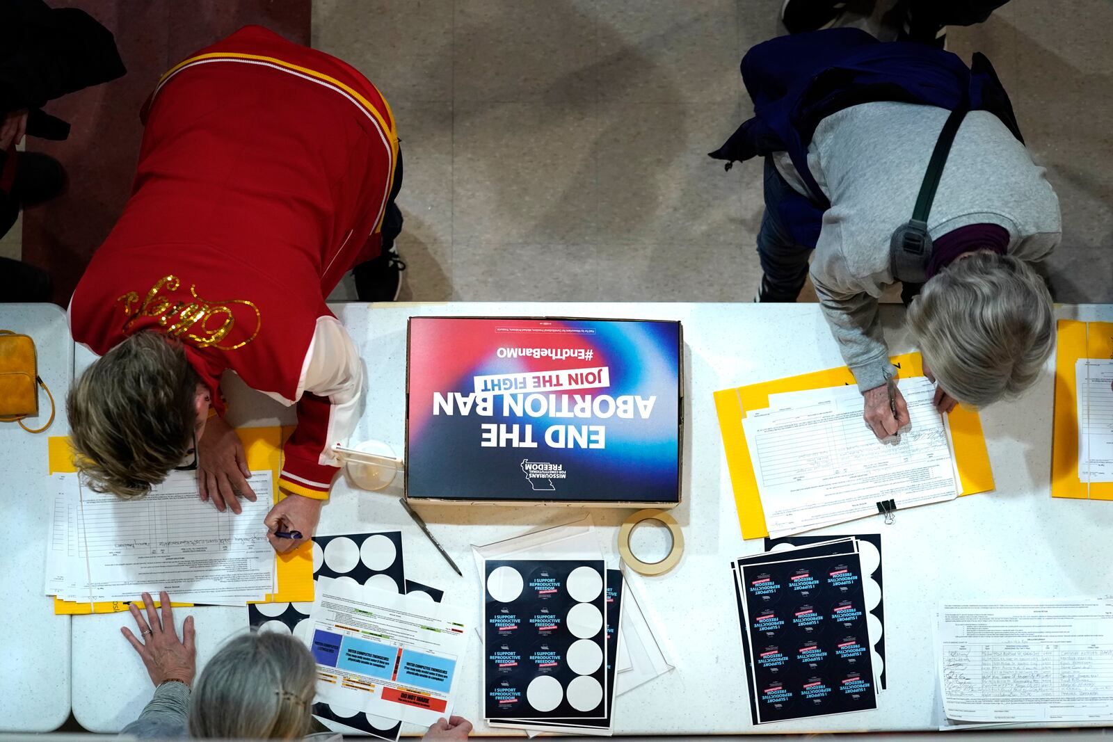 FILE - Residents place their signatures on a petition in support of a ballot initiative to end Missouri's near-total ban on abortion during Missourians for Constitutionals Freedom kick-off petition drive, Feb. 6, 2024, in Kansas City, Mo. (AP Photo/Ed Zurga, File)