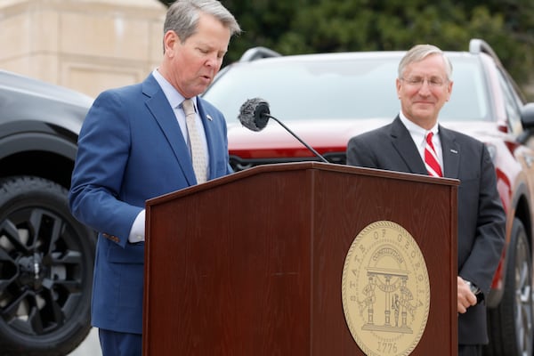 Gov. Brian Kemp speaks as Kia Georgia President and CEO Stuart Countess looks on at the first ever Kia Day at the State Capitol on Tuesday, January 31, 2023. Countess supports two bills pitched as a way to improve housing and workforce development. (Natrice Miller/The Atlanta Journal-Constitution) 