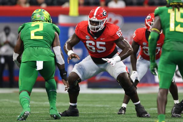 Bulldogs offensive lineman Amarius Mims (65) blocks Ducks linebacker DJ Johnson during their game at Mercedes-Benz Stadium. Georgia won 49-3. (Jason Getz / Jason.Getz@ajc.com)