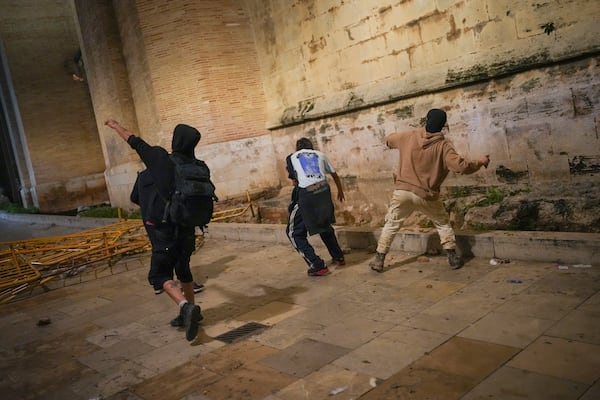 Demonstrators clash with riot police after a peaceful protest organized by social and civic groups, denouncing the handling of recent flooding under the slogan "Mazón, Resign," aimed at the president of the regional government Carlos Mazon, in Valencia, Spain, Saturday, Nov. 9, 2024. (AP Photo/Emilio Morenatti)