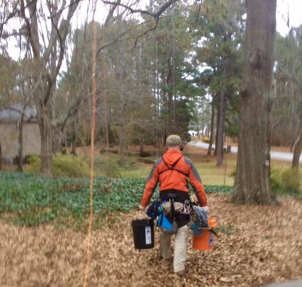 When attempting a cat rescue, Normer Adams approaches with about 30 pounds of gear on his belt. 