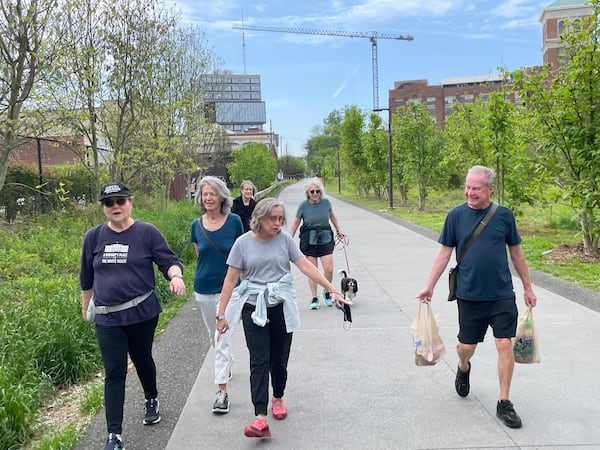 Annie Christopher, front right, chats with a  fellow coming from the Murder Kroger on the Atlanta Beltline. With her, from left, are Amy Shay, Chiara Waller, Sarah Bryant, Susanne Muntsing and her dog, Frankie. Photo by Bill Torpy