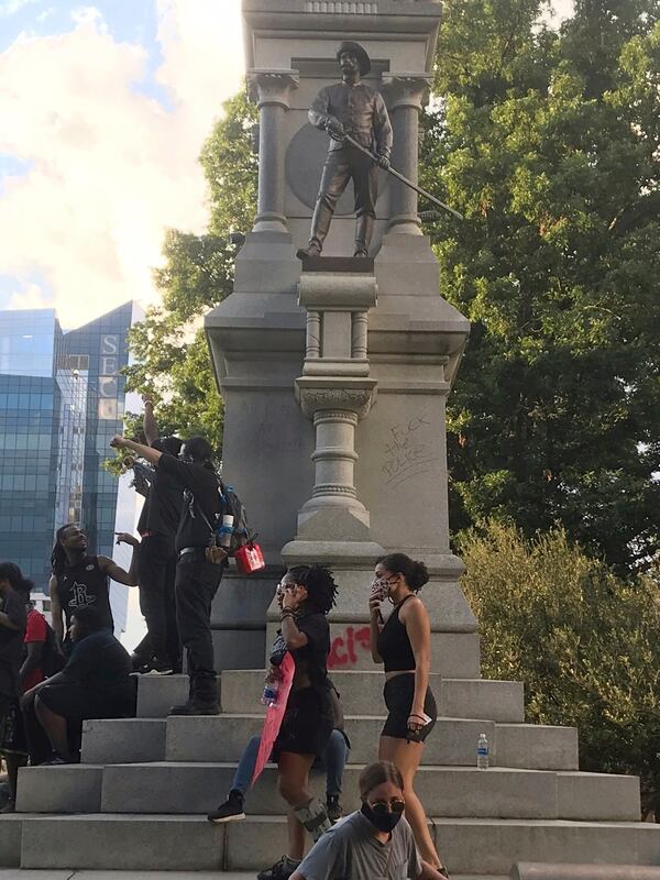 Protesters gather around the base of the Confederate monument on the grounds of the State Capitol in Raleigh, North Carolina.