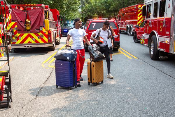 Tremaine Holifield (left) and Rmgud Allen, who were staying at the Arrive Perimeter apartment complex in Dunwoody, head out with their packed bags Sept. 12, 2021, after the explosion. (Steve Schaefer for The Atlanta Journal-Constitution)