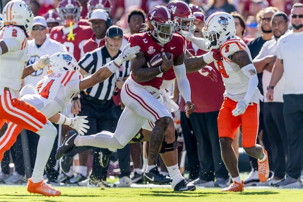 Alabama quarterback Jalen Milroe (4) runs the ball past Mercer safety Chris Joines (14) and cornerback Khalil Moody (9) during the first half of an NCAA college football game, Saturday, Nov. 16, 2024, in Tuscaloosa, Ala. (AP Photo/Vasha Hunt)