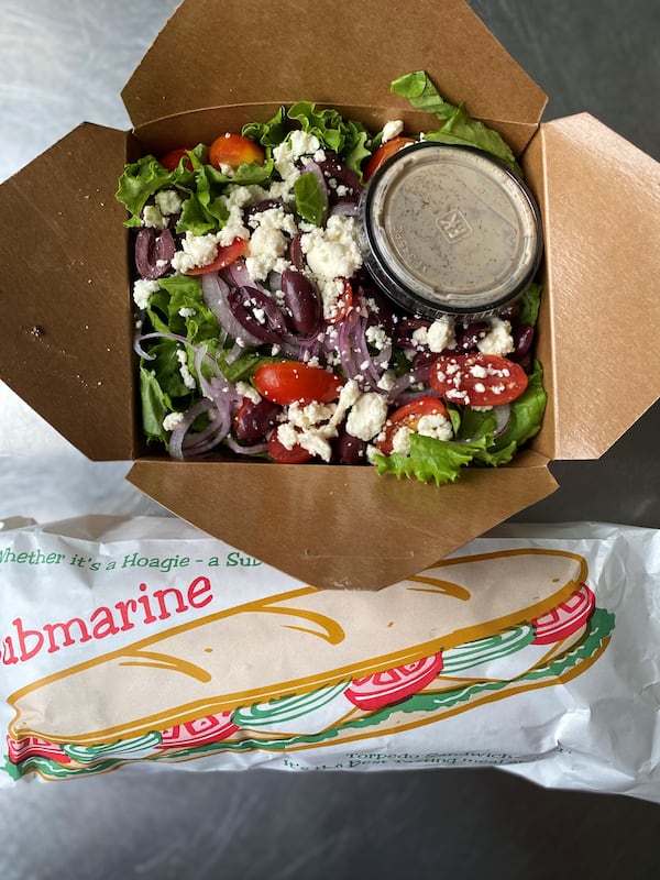 This takeout order from O4W Pizza in Duluth inludes a Greek salad and a Kitchen Sink sub. Wendell Brock for The Atlanta Journal-Constitution