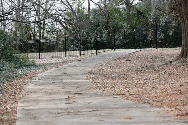 A black fence is seen between Grove at Five Points apartments and the intramural trails on the east side of the UGA campus as part of the new changes since Laken Riley was murdered there one year ago. (Miguel Martinez/AJC)