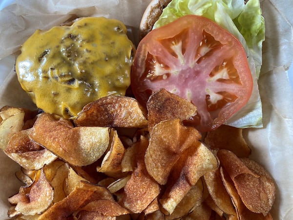 The Wheelhouse Burger consists of two patties, American cheese, lettuce, tomato and onion on a potato bun, served with a side of potato chips. Bob Townsend for The Atlanta Journal-Constitution 