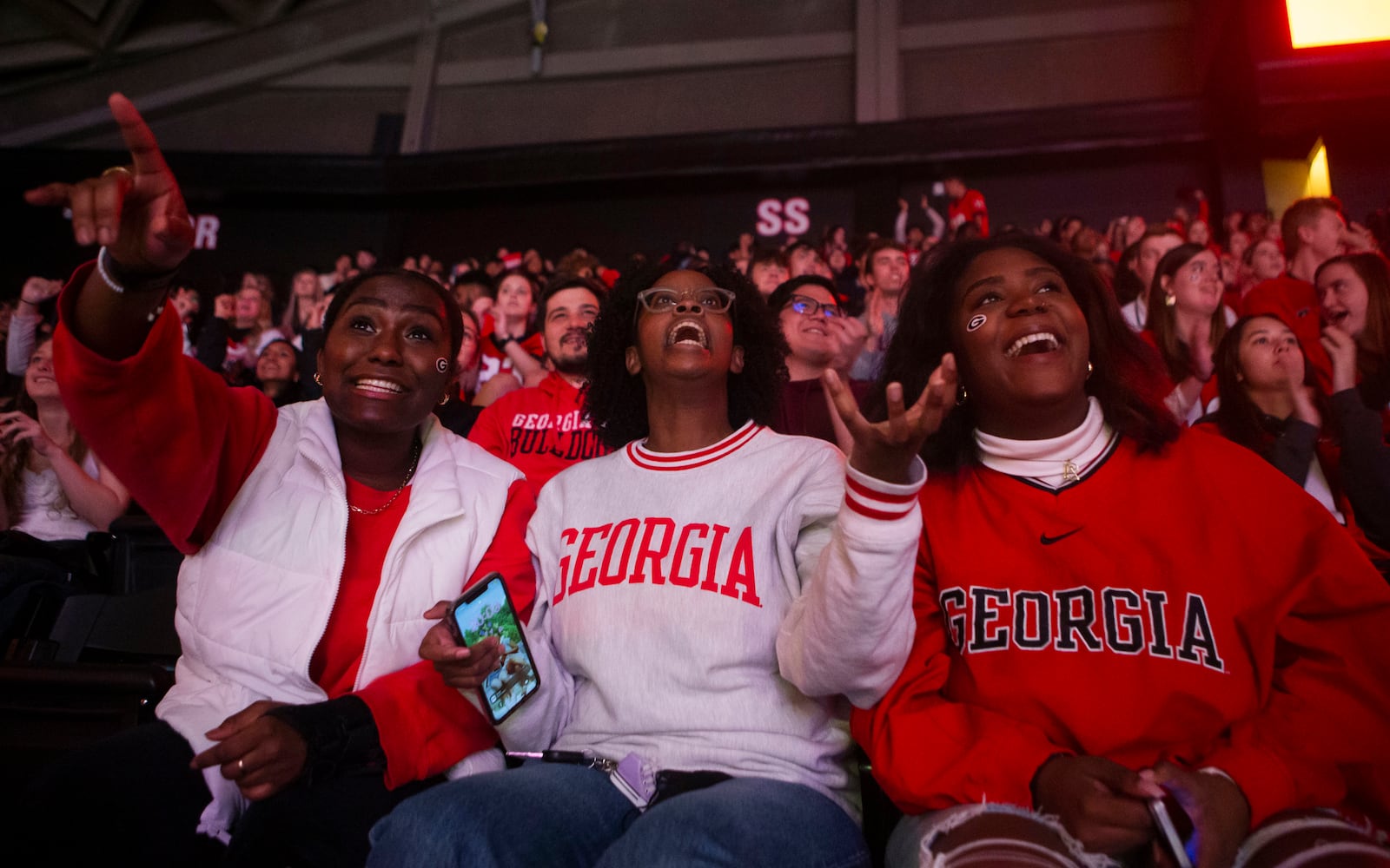 (Left to right) Kai Pope, Grace Saidi and Anna Anglin cheer on the Georgia Bulldogs during a watch party for the College Football Championship on Monday, January 9, 2023, at Stegeman Coliseum in Athens, Georgia. The University of Georgia defeated the Texas Christian University football team 65-7. CHRISTINA MATACOTTA FOR THE ATLANTA JOURNAL-CONSTITUTION.