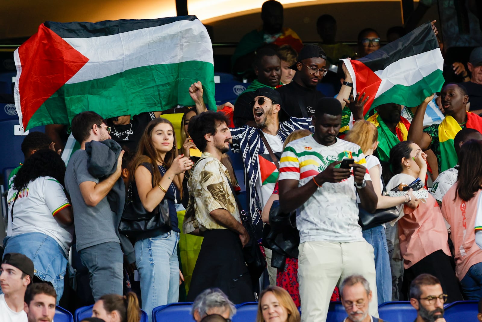 FILE - Spectators hold Palestinian flags as they watch the men's group D match between Israel and Mali at the Parc des Princes during the 2024 Summer Olympics, Wednesday, July 24, 2024, in Paris, France. (AP Photo/Aurelien Morissard, File)