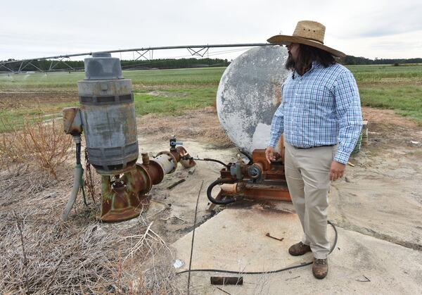 Christopher Worsham checks a well after turning on a farm irrigation system at his family farm in Vada in October. It’s been six years since Florida took its long-running water rights grievances against Georgia to the Supreme Court, and since then the focus of its suit has shifted from metro Atlanta to the farmland of southwest Georgia. (Hyosub Shin / Hyosub.Shin@ajc.com)