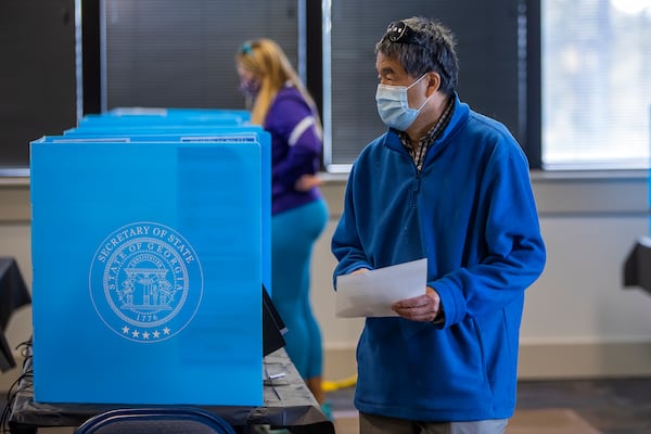 A voter participates in the first day of early voting for the Georgia US Senate runoff election at Shorty Howell Park in Duluth, Georgia, on Dec. 14, 2020.