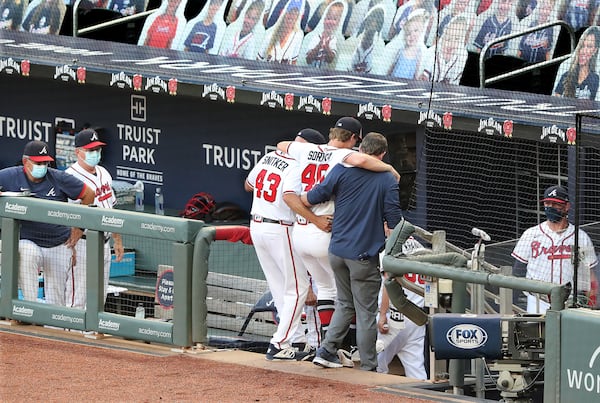 Braves manager Brian Snitker and a trainer help pitcher Mike Soroka off the field on Monday, August 3, 2020 in Atlanta.    Curtis Compton ccompton@ajc.com