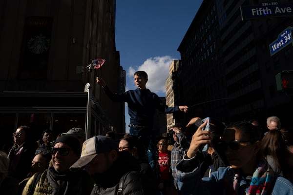 A boy waves an American flag as crowds watch the annual Veterans Day Parade, Monday, Nov. 11, 2024, in New York. (AP Photo/Adam Gray)