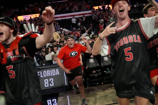 Georgia fans rush the court in celebration after an NCAA college basketball game against Florida, Tuesday, Feb. 25, 2025, in Athens, Ga. (AP Photo/Brynn Anderson)