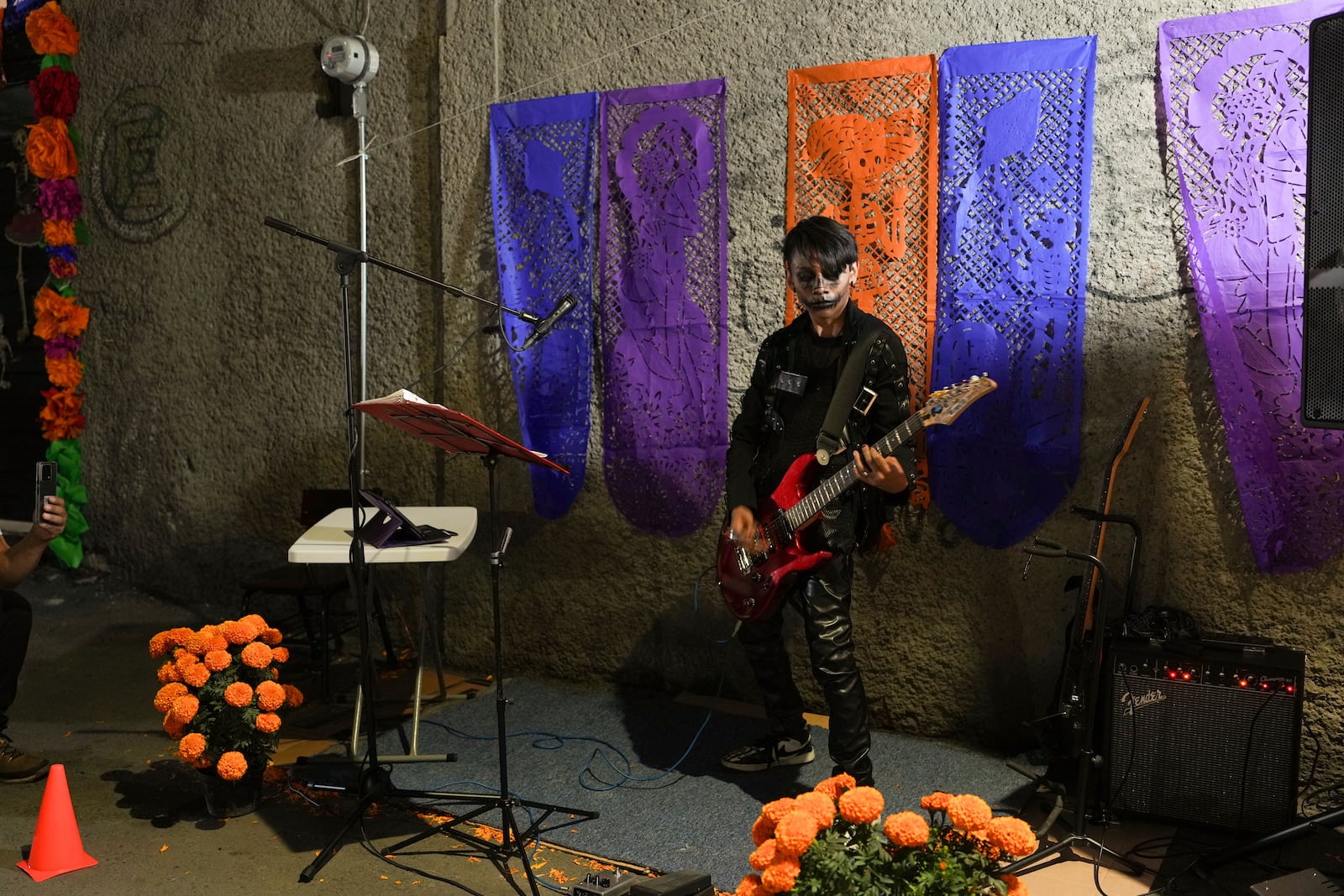 A musician performs people celebrate the Day of the Dead, near the San Gregorio Atlapulco cemetery on the outskirts of Mexico City, Friday, Nov. 1, 2024. (AP Photo/Moises Castillo)