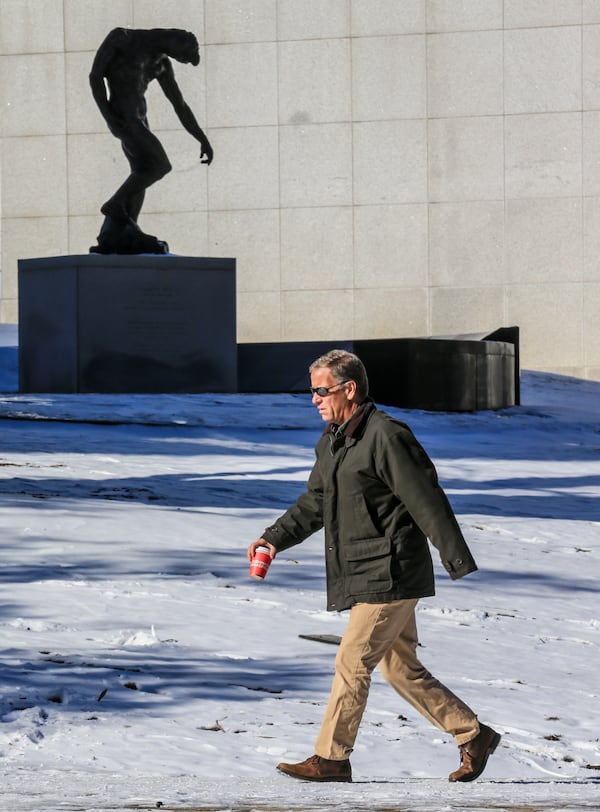 “The Shade” by Auguste Rodin looks out over a snowy High Museum lawn and Peachtree Street last  month. JOHN SPINK/JSPINK@AJC.COM