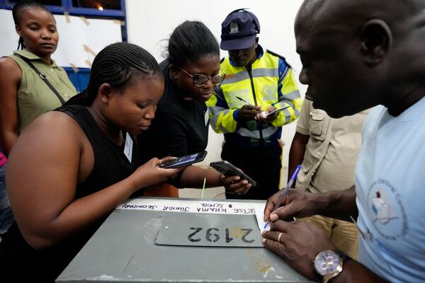 Party agents take a photo of a seal number of a ballot box after the closing of a voting station during the elections at Old Naledi township, on the outskirts of Gaborone, Botswana, Wednesday, Oct. 30, 2024. (AP Photo/Themba Hadebe)